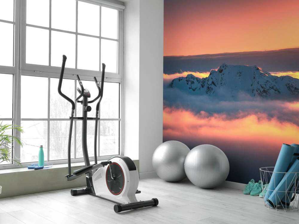 Besneeuwde bergtop in wolkenzee