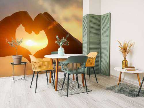 Hartvorm met handen tegen de heldere zon