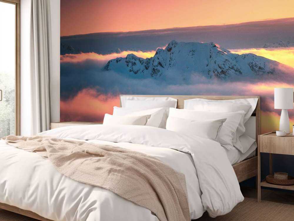 Besneeuwde bergtop in wolkenzee