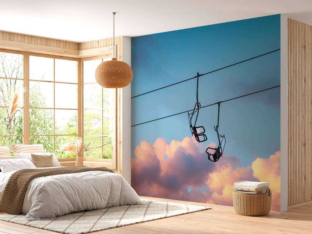 Stoeltjeslift boven roze avondwolken