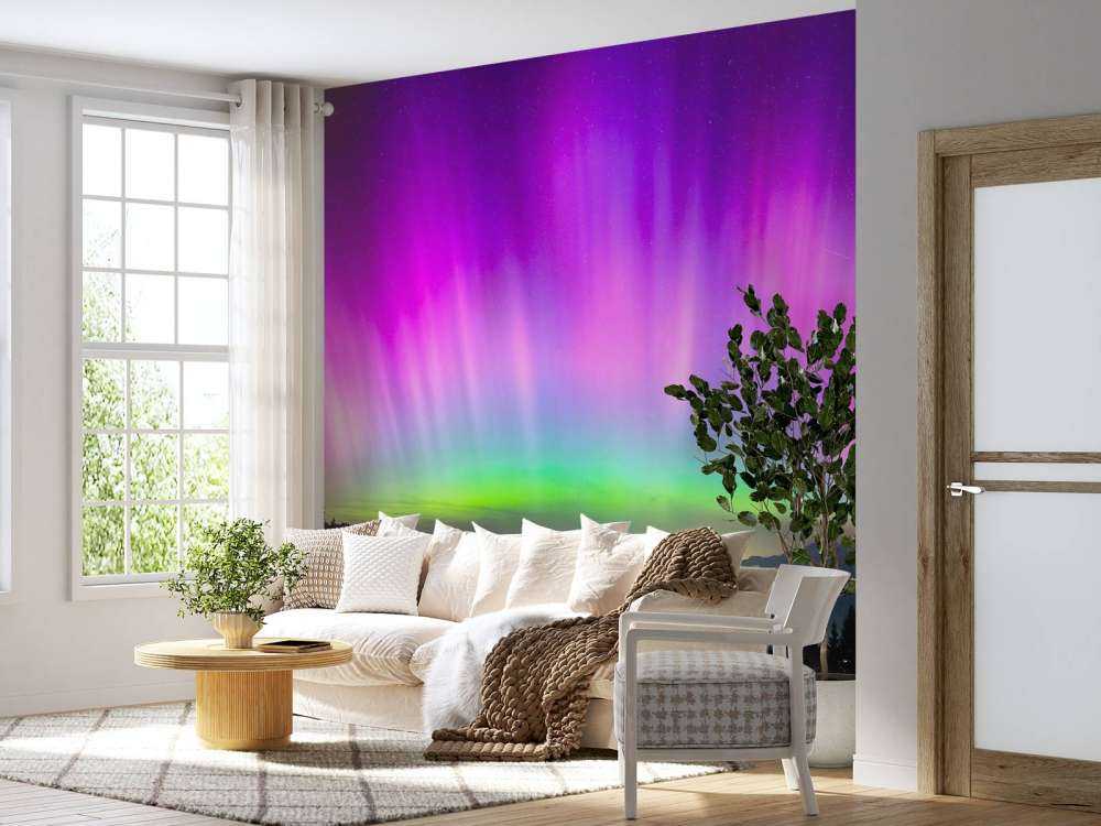 Noorderlicht boven verlichte bergstad