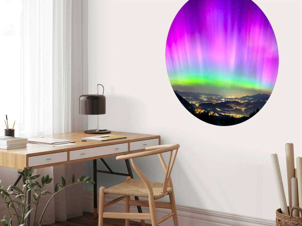 Noorderlicht boven verlichte bergstad