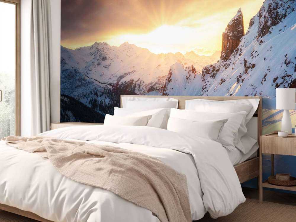 Avondzon achter besneeuwde bergtoppen