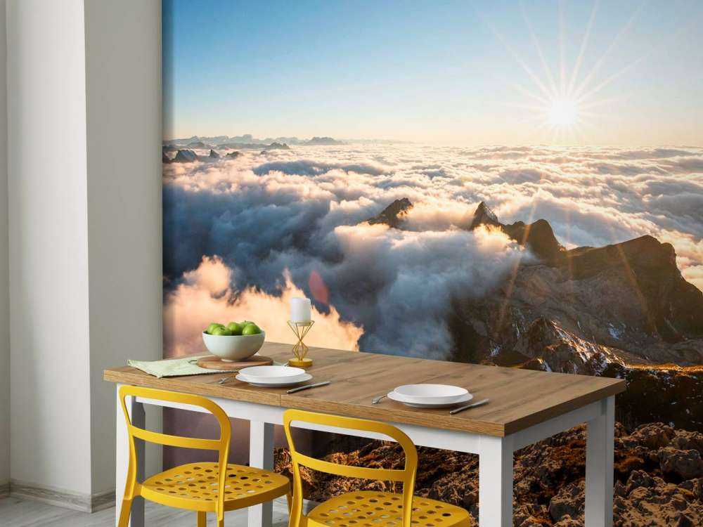 Zon boven wolkendek en bergtoppen