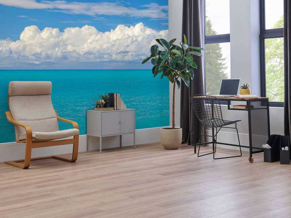 Panoramic view of a blue seascape with sailboat and cloudy sky