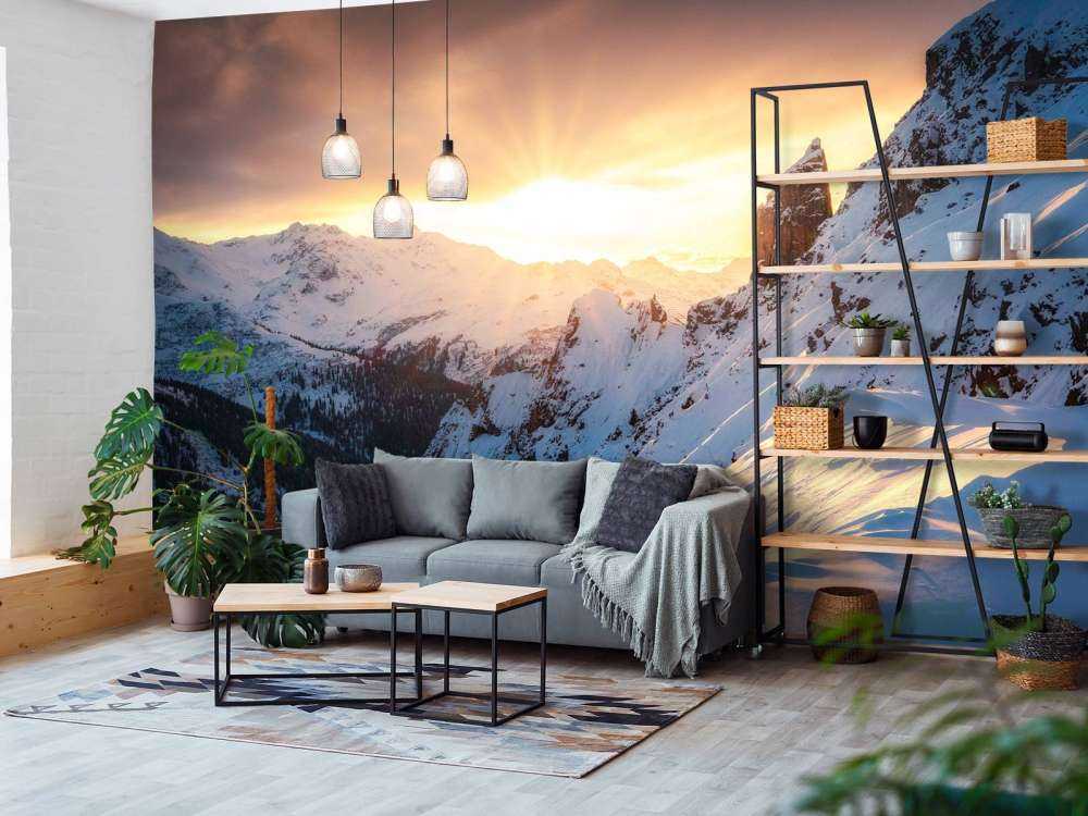 Avondzon achter besneeuwde bergtoppen