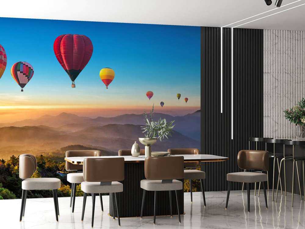 Grote groep luchtballonnen boven een mistig berglandschap