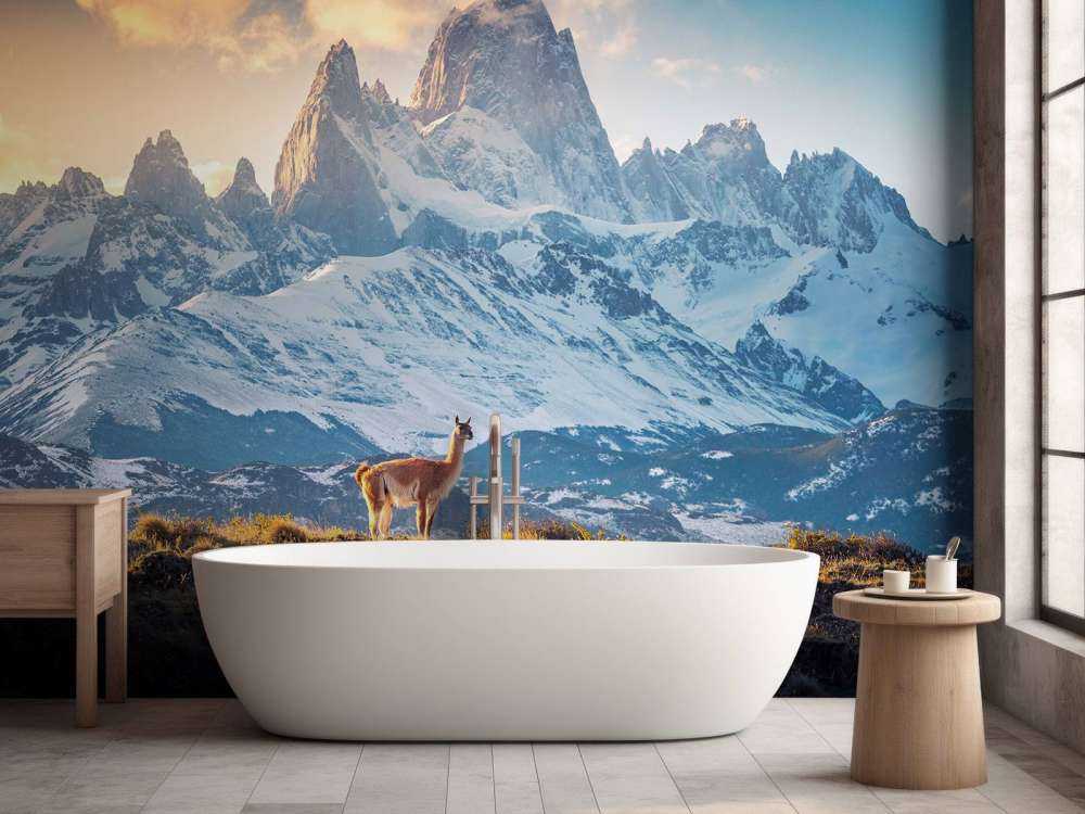 Guanaco bij besneeuwde bergtoppen