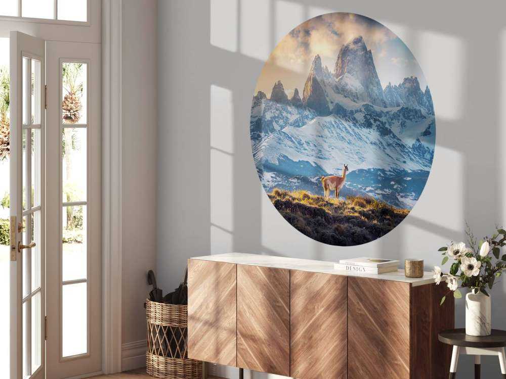 Guanaco bij besneeuwde bergtoppen