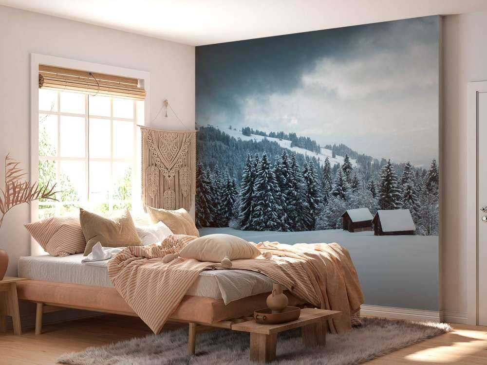 Besneeuwd dennenbos met houten hutten